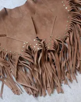 Chaleco de cuero color camel con flecos largos en el ruedo y tachas metálicas doradas decorativas en el frente.