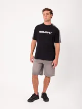 Remera negra de manga corta con diseño deportivo, parte superior de las mangas en color gris con ribete blanco y estampa frontal con la marca Rusty.