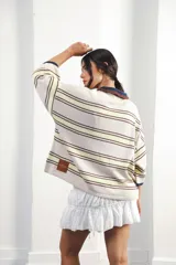 Remera rosa con rayas horizontales azul marino y bordó, cuello tipo polo marrón con botones y mangas cortas amplias.