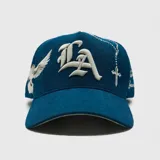 Gorra tipo baseball de pana color azul, con bordado frontal en tipografía gótica y bordado lateral de una paloma. Cuenta con ajuste posterior.