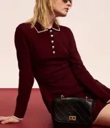 Vestido corto de punto color borgoña, con cuello polo blanco abotonado y mangas largas.