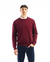 Buzo de punto liso color negro, con cuello redondo y puños y ruedo acanalados. Se lleva sobre una camisa celeste de vestir.