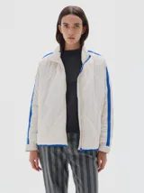 Campera acolchada color blanco hueso con cuello alto, cierre frontal y detalles de franjas azules en las mangas y el cuello.