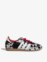 Championes Adidas modelo Japan W con diseño de estampado animal print tipo dálmata en pelo sintético. Presenta las tres franjas laterales en blanco, cordones rojos, forro interior rojo y suela de goma color caramelo.