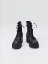 Bota de cuero tipo borceguí con cordones, cierre lateral metálico y taco cuadrado alto con plataforma. Presenta punta cuadrada y diseño robusto.