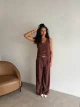 Chaleco de corte sastrero en tela tusor color beige con sutiles rayas verticales, escote en V y cierre frontal con botones al tono.