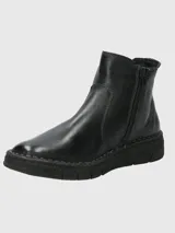 Bota tipo Chelsea de cuero negro, con paneles laterales elásticos y suela de goma flexible con costura vista en el borde.