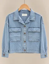 Sobrecamisa de denim celeste con bolsillos frontales con solapa y cierre de botones marrones, marca Magnolia.