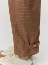 Pantalón de lino color blanco crudo, de corte barrel, con bolsillos laterales y costuras pespunteadas a contratono.
