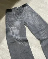 Jean de corte recto en color gris con efecto lavado y estampado de alas en la parte trasera.