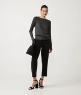 Suéter de punto color rosado, con cuello barco, mangas largas y puños con botones decorativos. El dobladillo también es acanalado.