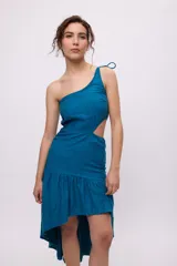 Vestido azul con bretel fino, escote asimétrico de un hombro, corte a la cintura con recorte en el lateral y falda midi con volados irregulares.