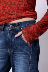 Jean slouch de tiro medio, color azul oscuro, con costuras decorativas en las piernas y diseño de paneles.