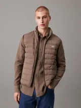 Chaleco acolchado marrón claro con cierre frontal con cremallera, cuello alto y bolsillos laterales.