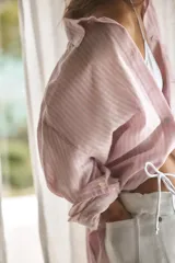 Camisa oversize de cuello solapa, manga larga con hombro caído y puños. Presenta un bolsillo de plastrón en el delantero y cierre frontal con botones.