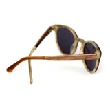 Lentes de sol Indie modelo Zac, con montura redonda color caramelo y lentes grises polarizadas.