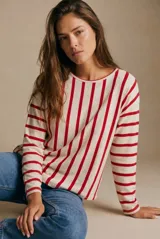 Remeron de corte oversize con cuello redondo y mangas largas. Presenta un diseño de rayas verticales en color rojo sobre base color crema.