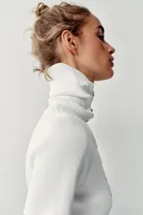 Top de punto rib color blanco, con cuello solapa, manga corta y cierre frontal con botones dorados.