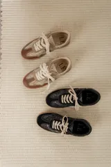 Championes urbanos de diseño acolchado, combinando tonos marrones, beige y detalles metalizados con textura. Cuentan con cordones al tono y suela de goma color caramelo.