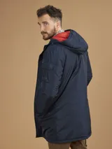 Campera de abrigo azul marino con capucha, cierre frontal con botones y cremallera, múltiples bolsillos y forro interior naranja.