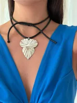 Gargantilla con cordón sintético negro y dije plateado con textura.