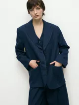 Blazer de corte sastrero en color azul marino con diseño de rayas diplomáticas. Presenta solapas clásicas, cierre frontal con un botón y bolsillos laterales con solapa.