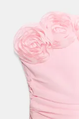 Top de escote recto y hombros descubiertos, color rosado, con aplicación de flores en relieve a lo largo del escote y detalle drapeado en el delantero. Cierre lateral con cremallera oculta.