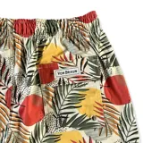 Short de baño Von Braun con estampado tropical de hojas y círculos en tonos rojos, amarillos y verdes sobre fondo claro. Cuenta con cintura elástica, dos bolsillos laterales, un bolsillo trasero con cierre y etiqueta de la marca.