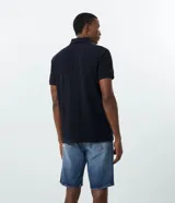 Remera polo de corte comfort, confeccionada en algodón peruano de alta calidad. Presenta cuello clásico con tapeta de botones y mangas cortas. Diseño liso y texturizado, ideal para un look casual y fresco.