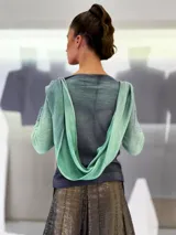 Buzo de doble tejido fino y suave 100% lana merino teñida artesanalmente. Cuenta con una pieza incorporada que permite enroscarla en el cuello a modo de bufanda o chall, dejarla libre hacia el frente o espalda, o enroscarla en el delantero de modo asimétrico. Los puños tienen un ojal para colocar el pulgar y oficiar de semi guantes. Prenda abrigada y confortable ideal para ser usada debajo de un cardigan. Creado y producido en Uruguay.