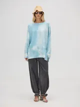 Buzo de algodón con estampado abstracto en tonos tierra y verde, de corte holgado y largo por debajo de la cintura, con puños acanalados.