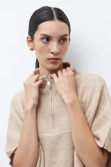 Sweater oversized color verde petróleo, con cuello alto y cierre frontal corto.