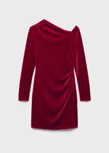 Vestido corto de terciopelo color rojo, con diseño asimétrico de un solo hombro y manga larga. Presenta un detalle de fruncido lateral que aporta un ajuste entallado a la silueta.