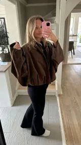 Campera tipo bomber de gamuza en color marrón, con cuello clásico, mangas largas amplias y ruedo elástico que genera un efecto fruncido.