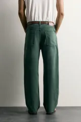 Jeans relaxed fit de algodón color verde oscuro, de tiro medio y pernera recta con raya de planchado. Cuenta con diseño de cinco bolsillos y cierre frontal con cremallera y botón.
