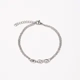 Pulsera plateada de doble cadena con eslabones y tres dijes centrales con forma de granos de café.