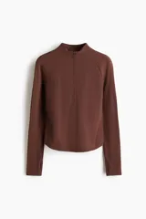 Top deportivo de manga larga en tejido funcional SculptMove, color marrón, con cuello elevado, medio cierre frontal y mangas raglán con abertura para el pulgar.