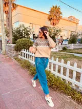 Sweater tostado tejido en lana con textura suave. Diseño con motivos geométricos en blanco y negro en la parte superior y bloque de color beige en la parte inferior.