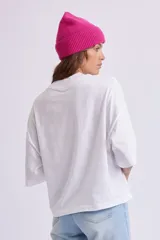 Remera blanca de manga 3/4 y cuello alto, con diseño oversize y corte recto.