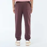 Pantalón de chándal color borgoña con cordones ajustables en la cintura.
