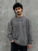 Buzo gris con cuello redondo, mangas largas y puños y bajo acanalados. Estampado frontal con el logo "Osten" y la frase "A mindset of becoming".