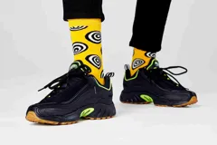 Medias amarillas con estampado de círculos concéntricos blancos y negros. Marca Happy Socks.