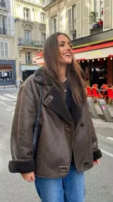 Chaqueta de gamuza marrón con interior de corderito sintético, diseño cruzado con botones y bolsillos laterales.