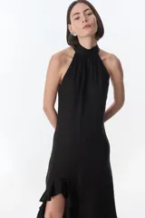 Vestido largo color verde oliva, con cuello halter fruncido y falda con abertura lateral con volados.