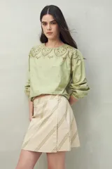 Minifalda de algodón con estampado botánico en tonos verde claro y beige, de corte recto.