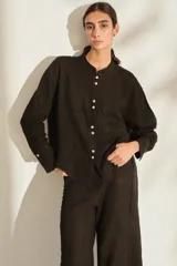 Camisa de lino italiano color beige, de corte holgado, con cuello mao, manga larga y bolsillo aplicado en el pecho.