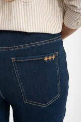 Jean de corte flare wide leg con tiro medio y ruedo desflecado. Confeccionado en denim de algodón, presenta un tono azul oscuro uniforme con costuras en contraste.