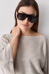Sweater de punto liviano negro, con escote bote y mangas amplias de largo tres cuartos que aportan una silueta relajada y fluida.