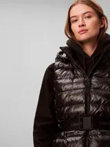 Chaleco puffer liviano marca Calvin Klein color negro, con diseño acolchado, capucha, cierre frontal y cinturón elástico con hebilla a presión y logo de la marca.