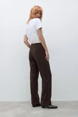 Pantalón tipo jogger de pana color chocolate, con cintura elástica y detalle de vivo en contraste en la parte superior.